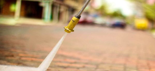 benefits-of-pressure-washing a pressure washer spraying water on a brick paver