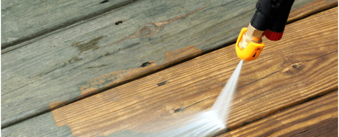 a technician is cleaning a porch with a pressure washer